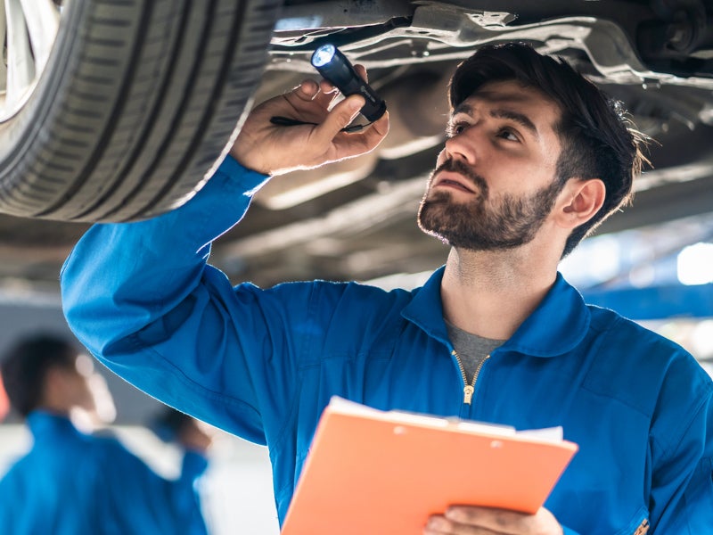 Technician working on a used car